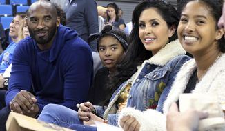 FILE - In this Nov. 21, 2017, file photo, from left, Los Angeles Lakers legend Kobe Bryant, his daughter Gianna Maria-Onore Bryant, wife Vanessa and daughter Natalia Diamante Bryant are seen before an NCAA college women&#39;s basketball game between Connecticut and UCLA, in Los Angeles. Vanessa Bryant says she is focused on “finding the light in darkness” in an emotional story in People magazine. She details how she attempts to push forward after her husband, Kobe Bryant, and daughter Gigi died in a helicopter crash in early 2020. (AP Photo/Reed Saxon, File)