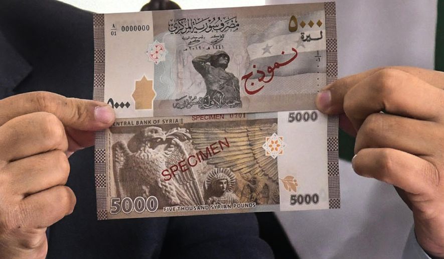 FILE - In this Jan. 24, 2021 file photo released by the Syrian official news agency SANA, Iyed Bilal, the director of the treasury department of the Syrian Central Bank, holds the new banknote of 5000 Syrian pounds during a press briefing, in Damascus, Syria. The Syrian pound hit a record low against the U.S. dollar, Wednesday, March 3, 2021, just days before the Arab country marks the 10th anniversary of a conflict that has left hundreds of thousands dead and large swaths destroyed. (SANA via AP, File)