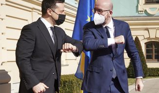 In this handout photo provided by the Ukrainian Presidential Press Office, Ukrainian President Volodymyr Zelenskiy, left, and European Council President Charles Michel bump elbows as they meet in Kyiv, Ukraine, Wednesday, March 3, 2021. (Ukrainian Presidential Press Office via AP)