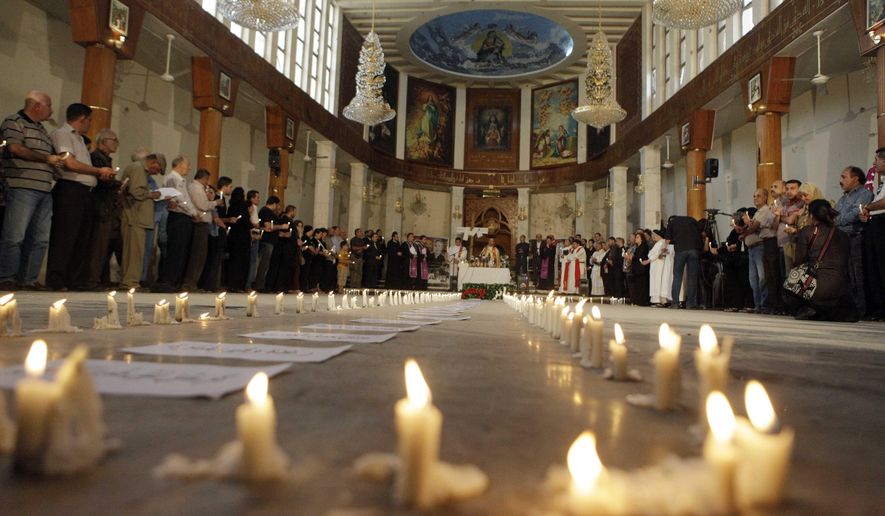 FILE - In this Nov. 7 2010, followers attend a mass at Our Lady of Salvation church in Baghdad, Iraq. Iraqi Christians have gathered for mass in the same church that just a week before was the scene of a horrific bloodbath that left scores dead and wounded. Pope Francis is pushing ahead with the first papal trip to Iraq despite rising coronavirus infections, hoping to encourage the country’s dwindling number of Christians who were violently persecuted during the Islamic State insurgency while seeking to boost ties with the Shiite Muslim world. (AP Photo/Khalid Mohammed)