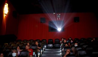 People watch a movie at a cinema after almost a year of theaters being closed due to the COVID-19 pandemic, in Buenos Aires, Argentina, Wednesday, March 3, 2021. (AP Photo/Natacha Pisarenko)