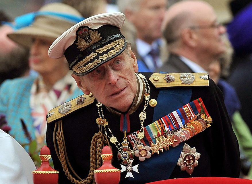 A Sunday June 3, 2012, photo from files showing Prince Philip watching the proceedings from the royal barge during the Diamond Jubilee Pageant on the River Thames in London. Buckingham Palace said Thursday March 4, 2021, that Prince Philip has undergone a successful procedure for a pre-existing heart condition, and will remain in hospital "for a number of days." (AP Photo/John Stillwell, Pool File)