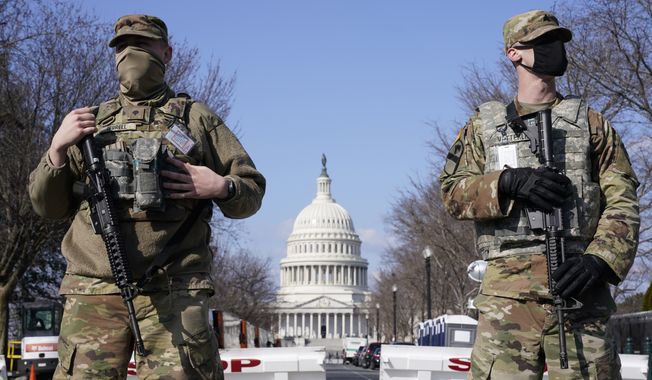 In this file photo, National Guard troops keep watch on the Capitol, Thursday, March 4, 2021, on Capitol Hill in Washington. (AP Photo/Jacquelyn Martin) ** FILE **