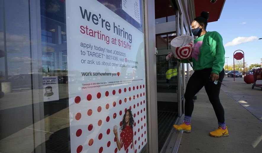 In this Sept. 30, 2020, photo, a passerby walks past a hiring sign while entering a Target store in Westwood, Mass. (AP Photo/Steven Senne) **FILE**