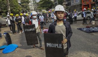 Anti-coup protesters with makeshift shields stand during a rally in Yangon, Myanmar, Wednesday, March 3, 2021. Demonstrators in Myanmar took to the streets again on Wednesday to protest last month&#39;s seizure of power by the military. (AP Photo)
