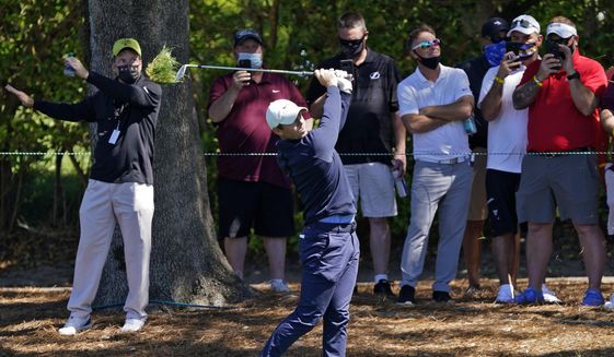 Rory McIlroy, of Northern Ireland, hits from the rough in front of the gallery on the ninth hole during the first round of the Arnold Palmer Invitational golf tournament Thursday, March 4, 2021, in Orlando, Fla. (AP Photo/John Raoux)