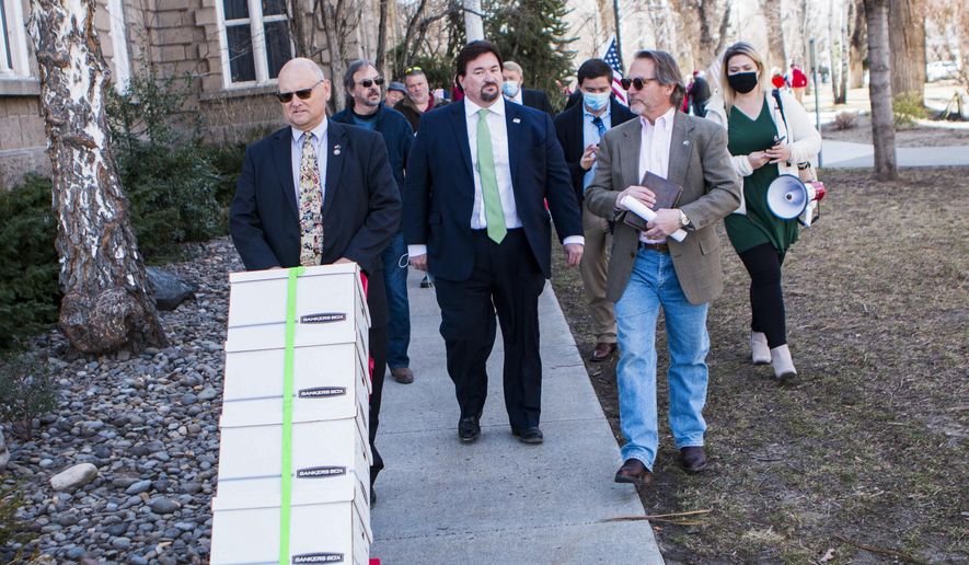The Nevada GOP and supporters haul a cart carrying what they described as 120,000 &amp;quot;election integrity violation reports&amp;quot; at the State Capitol, Thursday, March 4, 2021, in Carson City, Nev., alleging widespread voter fraud during the 2020 election. (Ricardo Torres-Cortez/Las Vegas Sun via AP)