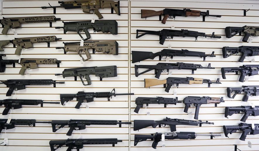 In this Oct. 2, 2018, file photo, semi-automatic rifles fill a wall at a gun shop in Lynnwood, Wash. With Democrats controlling the presidency and Congress, Republican state lawmakers concerned about the possibility of new federal gun control laws aren't waiting to react. Legislation in at least a dozen states seeks to nullify any new restrictions, such as ammunition limits or a ban on certain types of weapons. (AP Photo/Elaine Thompson, File)