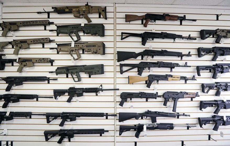 In this Oct. 2, 2018, file photo, semi-automatic rifles fill a wall at a gun shop in Lynnwood, Wash. With Democrats controlling the presidency and Congress, Republican state lawmakers concerned about the possibility of new federal gun control laws aren't waiting to react. Legislation in at least a dozen states seeks to nullify any new restrictions, such as ammunition limits or a ban on certain types of weapons. (AP Photo/Elaine Thompson, File)