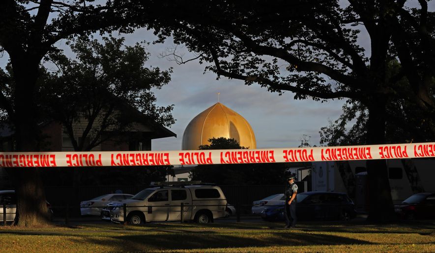 FILE - In this March 17, 2019, file photo,  police officer stands guard in front of the Masjid Al Noor mosque in Christchurch, New Zealand, where one of two mass shootings occurred. A New Zealand man is facing criminal charges after allegedly posting online threats against two Christchurch mosques that were the sites of a terrorist attack that left 51 people dead.Police on Thursday, March 4, 2021, arrested the 27-year-old man and charged him with threatening to kill. If found guilty, he faces a maximum prison sentence of seven years. (AP Photo/Vincent Yu, File)