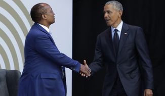 FILE - In this file photo dated Tuesday, July 17, 2018, former US President Barack Obama, right, shakes hands with Patrice Motsepe, as he arrives at the Wanderers Stadium in Johannesburg, South Africa, to deliver the 16th Annual Nelson Mandela Lecture.  The election to lead African soccer is seeming to be dominated by FIFA president Gianni Infantino, who supports South African billionaire Patrice Motsepe to win the top job in a ballot next week. (AP Photo/Themba Hadebe, FILE)