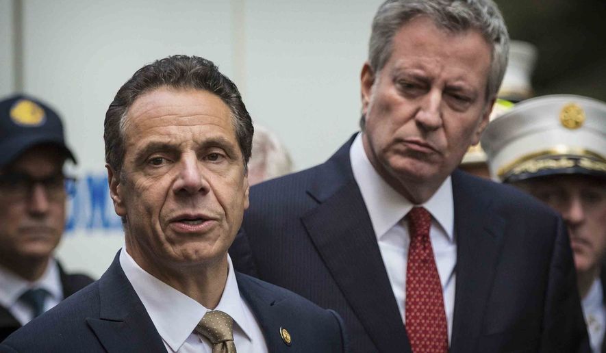 FILE - This photo from Wednesday, Oct. 24, 2018, shows Mayor Bill de Blasio right, and Gov. Andrew Cuomo, left, holding a news conference in New York. De Blasio said he watched the CBS interview Thursday with Cuomo accuser Charlotte Bennett and said he found her &quot;just 100% believable.&quot; Bennett, 25, is accusing Gov. Cuomo of sexual harassment when she worked as his aide. (AP Photo/Kevin Hagen, File).
