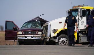 In this Tuesday, March 2, 2021, file photo, law enforcement officers work at the scene of a deadly crash in Holtville, Calif. Nine migrants in an SUV packed with 25 people that drove through an opening in a border wall suffered major injuries after their vehicle slammed into a tractor-trailer and killed 13 others inside, the California Highway Patrol said Thursday, March 4, 2021. (AP Photo/Gregory Bull, File)