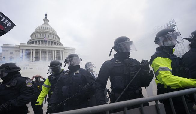 In this Jan. 6, 2021, file photo, police stand guard after holding off rioters who tried to break through a police barrier at the Capitol in Washington. (AP Photo/Julio Cortez, File)