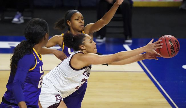 Texas A&amp;amp;M forward N&#x27;dea Jones, right, reaches for the ball against LSU guard Khayla Pointer, left, during the first half of an NCAA college basketball game during the Southeastern Conference tournament Friday, March 5, 2021, in Greenville, S.C. (AP Photo/Sean Rayford)