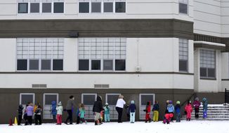 FILE - In this Nov. 11, 2020, file photo, second-graders line up to return to class at the end of recess at Longfellow Elementary School in Bozeman, Mont. Montana Gov. Greg Gianforte signed into law on Friday, March 5, 2020, a measure aimed at increasing starting teacher pay, making good on a promise from his election campaign. The measure creates financial incentives for school districts to increase salaries of educators who are in their first three years of teaching. (Rachel Leathe/Bozeman Daily Chronicle via AP)