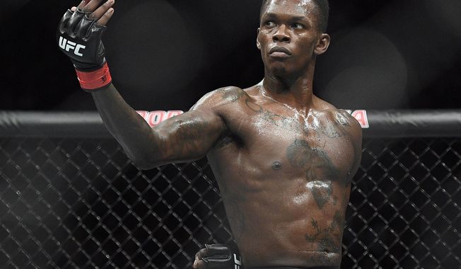 FILE - In this Feb. 10, 2019, file photo, Nigeria&#x27;s Israel Adesanya poses as he fights Brazil&#x27;s Anderson Silva in their middleweight bout at the UFC 234 mixed martial arts fights in Melbourne, Australia. Adesanya challenges champion Jan Blachowicz of Poland for the light heavyweight title in the main event of UFC 259 on Saturday in Las Vegas.  (AP Photo/Andy Brownbill, File)