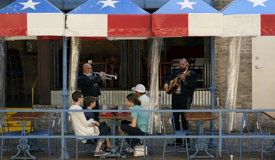 FILE - In this March 3, 2021, file photo, mariachi perform for diners at a restaurant on the River Walk in San Antonio. U.S. employers added a surprisingly robust 379,000 jobs in February in a sign the economy is strengthening as virus cases drop, vaccinations ramp up, Americans spend more and states ease business restrictions. Texas joined some other states in announcing it will fully reopen its economy. (AP Photo/Eric Gay, File)