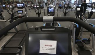 This July 2, 2020, file photo shows some gym equipment machines are turned off so clients can physically distance at Mountainside Fitness in Phoenix. (AP Photo/Ross D. Franklin, File)