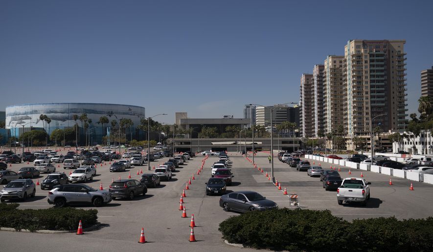 Motorists line up at a COVID-19 vaccination site in Long Beach, Calif., Friday, March 5, 2021. More than 27 million Americans fully vaccinated against the coronavirus will have to keep waiting for guidance from U.S. health officials for what they should and shouldn't do. The Biden administration said Friday it's focused on getting the guidance right and accommodating emerging science. (AP Photo/Jae C. Hong)