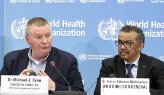 FILE - In this Monday, Feb. 24, 2020 file photo, Michael Ryan, left, Executive Director of WHO&#39;s Health Emergencies programme, next to Tedros Adhanom Ghebreyesus, right, Director General of the World Health Organization (WHO), addresses a press conference about the update on COVID-19 at the World Health Organization headquarters in Geneva, Switzerland. The emergencies chief of the World Health Organization said on Monday March 1, 2021, it was “premature” and “unrealistic” to think the pandemic might be stopped by the end of the year, but that the recent arrival of effective vaccines could at least help dramatically reduce hospitalizations and death. (Salvatore Di Nolfi/Keystone via AP, File)