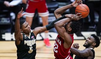 Indiana forward Jordan Geronimo, center, is fouled as he shoots by Purdue guard Brandon Newman, left, during the first half of an NCAA college basketball game in West Lafayette, Ind., Saturday, March 6, 2021. (AP Photo/Michael Conroy)