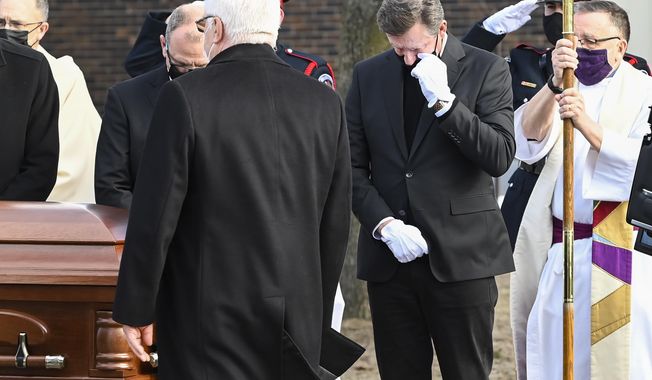 Hockey hall-of-fame legend Wayne Gretzky, right, watches the casket of his father, Walter Gretzky, as it is carried from the church during a funeral service in Brantford, Ontario, Saturday, March 6, 2021. Walter Gretzky, also known as Canada&#x27;s hockey dad was 82 years old. (Nathan Denette/The Canadian Press via AP)