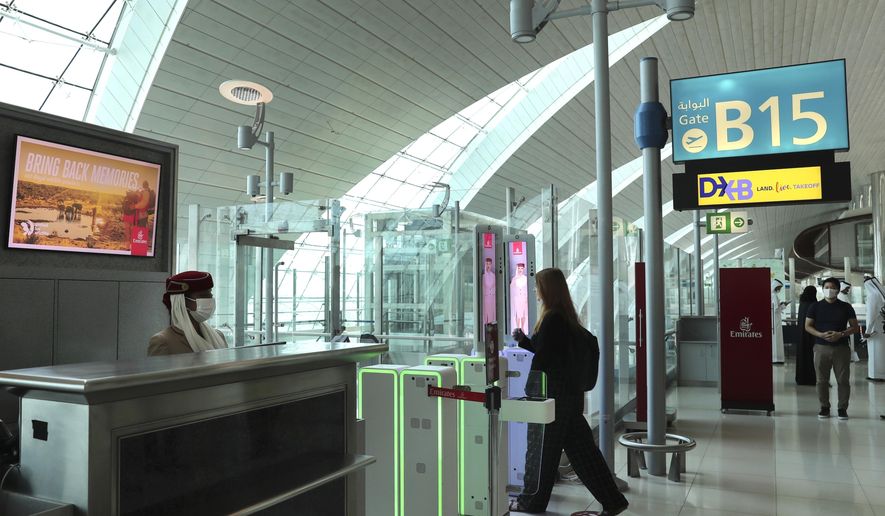 A woman enters the face and iris-recognition gate to board a plane, during a media tour at Dubai Airport, in the United Arab Emirates, Sunday, March 7, 2021. Dubai&#x27;s airport, the world’s busiest for international travel, has introduced an iris-scanner that verifies one’s identity and eliminates the need for any human interaction when leaving the country. It’s the latest artificial intelligence program the UAE has launched amid the surging coronavirus pandemic. (AP Photo/Kamran Jebreili)
