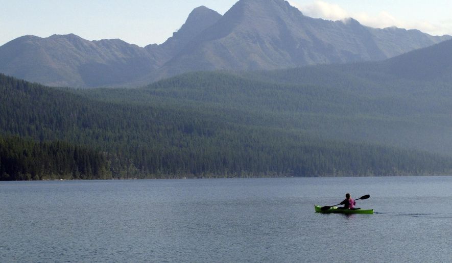 FILE - In this Sept. 6, 2013, file photo, Ingrid Forsmark kayaks on Kintla Lake in Glacier National Park, Mont. Public access to Glacier National Park&#x27;s east entrances has been prohibited since March 2020, as a result of the COVID-19 pandemic, creating worries for businesses that rely on tourism. (AP Photo/Matt Volz, File)