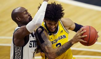 Michigan forward Isaiah Livers (2) is defended by Michigan State guard Joshua Langford (1) during the first half of an NCAA college basketball game, Sunday, March 7, 2021, in East Lansing, Mich. (AP Photo/Carlos Osorio)