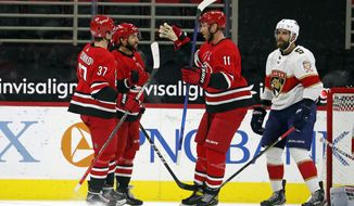 Carolina Hurricanes&#x27; Vincent Trocheck (16), center, is congratulated on his goal by teammates Jordan Staal (11) and Andrei Svechnikov (37) with Florida Panthers&#x27; Aaron Ekblad (5) nearby during the first period of an NHL hockey game in Raleigh, N.C., Sunday, March 7, 2021. (AP Photo/Karl B DeBlaker)