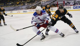 New York Rangers&#39; Julien Gauthier (12) and Pittsburgh Penguins&#39; Brian Dumoulin (8) chase the puck during the second period of an NHL hockey game, Sunday, March 7, 2021, in Pittsburgh. (AP Photo/Keith Srakocic)