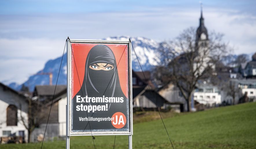 A poster supporting the initiative &#x27;Yes to a ban on covering the face&#x27; is displayed at the village Buochs, Switzerland, Tuesday, Feb. 16, 2021. At a time when seemingly everyone in Europe is wearing masks to battle COVID-19, the Swiss go to the polls Sunday March 7, 2021, to vote on a long-laid proposal to ban face-coverings like niqabs and burqas worn by some Muslim women or by protesters in ski masks or bandannas. (Urs Flueeler/Keystone via AP)