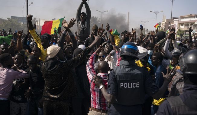 Demonstrators shout slogans in front of riot policemen during a protest against the arrest of opposition leader and former presidential candidate Ousmane Sonko, Senegal, Monday, March 8, 2021. Senegalese authorities have freed opposition leader Ousmane Sonko while he awaits trial on charges of rape and making death threats. The case already has sparked deadly protests threatening to erode Senegal&#x27;s reputation as one of West Africa’s most stable democracies. (AP Photo/Leo Correa)