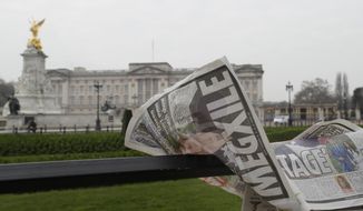 A newspaper is blown by the wind after it is placed on a railing by a television crew outside Buckingham Palace in London, Monday, March 8, 2021. Britain&#39;s royal family is absorbing the tremors from a sensational television interview by Prince Harry and the Duchess of Sussex, in which the couple said they encountered racist attitudes and a lack of support that drove Meghan to thoughts of suicide. (AP Photo/Kirsty Wigglesworth)