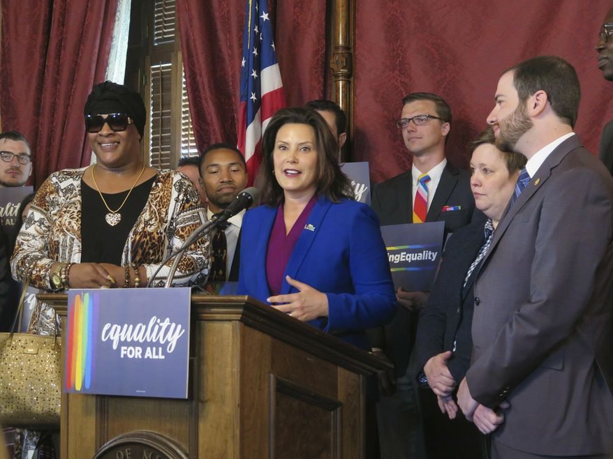 FILE - In this June 4, 2019, file photo, Michigan Gov. Gretchen Whitmer, center, joins with lawmakers and others in the Capitol building in Lansing, Mich., calling for expanding the state's civil rights law to prohibit discrimination against LGBT people. LGBTQ protections will be added to state civil rights law either by the legislative process or Michigan voter approval, two state legislators vowed Monday, March 8, 2021. (AP Photo/David Eggert, File)