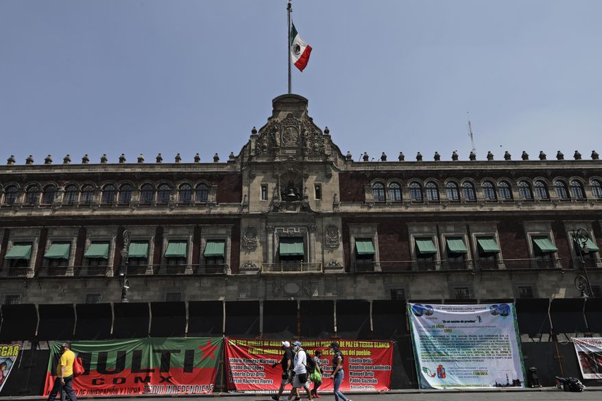 Banners with messages directed at Mexico&#39;s President Andres Manuel Lopez Obrador hang from a perimeter fence set up in front of the National Palace as preparation for the upcoming International Women&#39;s Day demonstration, in Mexico City, Friday, March 5, 2021. Marked on March 8th, the day has been sponsored by the United Nations since 1975, to celebrate women’s achievements and aims to further their rights. (AP Photo/Eduardo Verdugo)