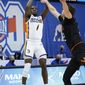 UNC-Greensboro guard Isaiah Miller (1) shoots for the basket over Mercer forward Felipe Haase (22) in the first half of an NCAA men&#x27;s college basketball championship game for the Southern Conference tournament, Monday, March 8, 2021, in Asheville, N.C. (AP Photo/Kathy Kmonicek)