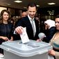 FILE - This April 13, 2016 file photo released on the official Facebook page of Syrian Presidency, shows Syrian President Bashar Assad casting his ballot in the parliamentary elections, as his wife Asma, left, stands next to him, in Damascus, Syria. The office of Syrian President Bashar Assad said Monday, March 8, 2021 that Assad and his wife have tested positive for the coronavirus and are both doing well. In a statement, Assad’s office said the first couple did PCR tests after they felt minor symptoms consistent with the COVID-19 illness. (Syrian Presidency via AP, File)