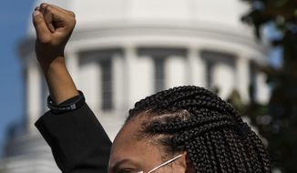 Satura Dudley holds up her fist during a protest of HB445 at the Alabama Statehouse in Montgomery, Ala., on Tuesday March 9, 2021. The bill would broaden the definitions and penalties for rioting. (Mickey Welsh/The Montgomery Advertiser via AP)
