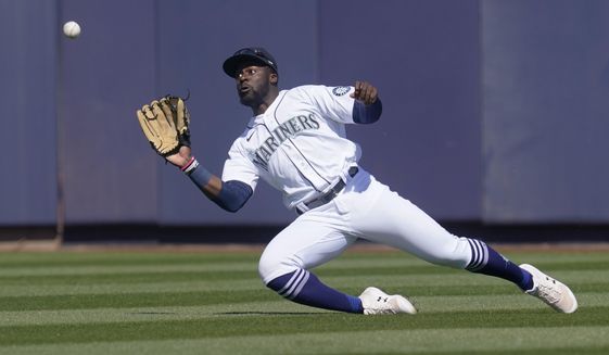 Seattle Mariners center fielder Taylor Trammell catches a fly ball hit by Oakland Athletics&#39; Greg Deichmann during the second inning of a spring training baseball game Saturday, March 6, 2021, in Peoria, Ariz. (AP Photo/Sue Ogrocki)