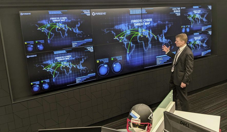 The CEO of FireEye Kevin Mandia gives a tour of the cybersecurity company's unused office space in Reston, Va., Tuesday, March 9, 2021. Mandia said 550 of his employees are working remotely and responding to a recent barrage of cyber breaches, including four different zero-day attacks against Microsoft Exchange. (AP Photo/Nathan Ellgren)