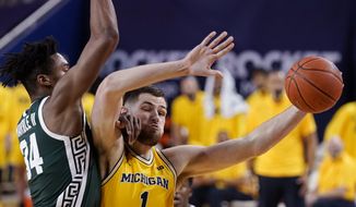 Michigan center Hunter Dickinson (1) is fouled by Michigan State forward Julius Marble II (34) during the first half of an NCAA college basketball game Thursday, March 4, 2021, in Ann Arbor, Mich. (AP Photo/Carlos Osorio) **FILE**