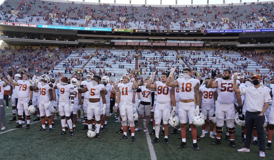 In this Saturday, Oct. 24, 2020, file photo, Texas players, including Sam Ehlinger (11), sing "The Eyes Of Texas" after an NCAA college football game against Baylor in Austin, Texas. The University of Texas' long-awaited report on the history of the school song “The Eyes of Texas” found it had “no racist intent,” but the school will not require athletes and band members to participate in singing or playing it at games and campus events. The song had erupted in controversy in 2020 after some members of the football team demanded the school stop playing it because of racist elements in the song’s past. (AP Photo/Chuck Burton, File) **FILE**