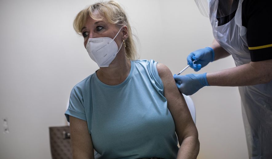Yvette Pau, 56, receives the second dose of the Pfizer-BioNTech COVID-19 vaccine, in Gibraltar, Thursday, March 4, 2021. Gibraltar, a densely populated narrow peninsula at the mouth of the Mediterranean Sea, is emerging from a two-month lockdown with the help of a successful vaccination rollout. The British overseas territory is currently on track to complete by the end of March the vaccination of both its residents over age 16 and its vast imported workforce. But the recent easing of restrictions, in what authorities have christened “Operation Freedom,” leaves Gibraltar with the challenge of reopening to a globalized world with unequal access to coronavirus jabs. (AP Photo/Bernat Armangue) **FILE**