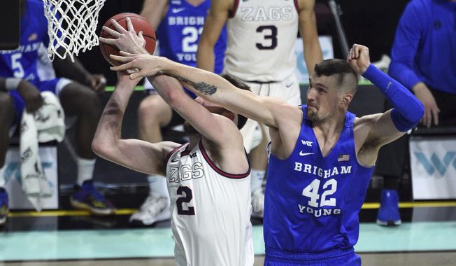 BYU center Richard Harward (42) defends against Gonzaga forward Drew Timme during the first half of an NCAA college basketball game for the West Coast Conference men&#x27;s tournament championship Tuesday, March 9, 2021, in Las Vegas. (AP Photo/David Becker)