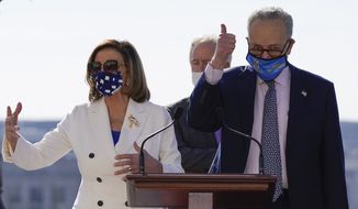 House Speaker Nancy Pelosi of Calif., and Senate Majority Leader Chuck Schumer of N.Y., gesture during an enrollment ceremony for the $1.9 trillion COVID-19 relief bill, on Capitol Hill, Wednesday, March 10, 2021, in Washington. (AP Photo/Alex Brandon)