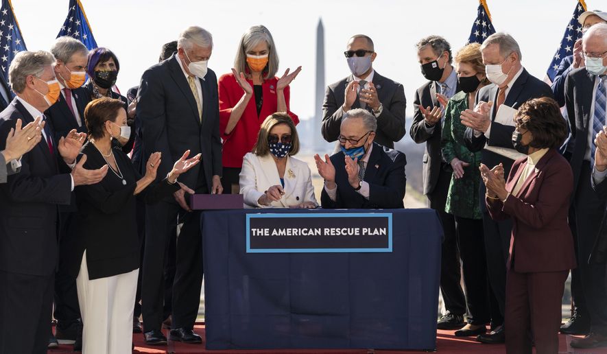 House Speaker Nancy Pelosi of Calif., and Senate Majority Leader Chuck Schumer of N.Y., celebrate after signing the $1.9 trillion COVID-19 relief bill, during an enrollment ceremony on Capitol Hill, Wednesday, March 10, 2021, in Washington. (AP Photo/Alex Brandon)