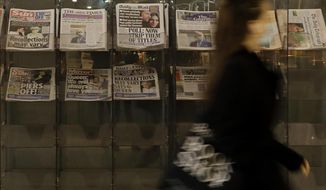 A pedestrian passes newspapers on display with front pages featuring images of members of the royal family, outside a shop in London, Wednesday, March 10, 2021. In countries with historic ties to Britain, allegations by Prince Harry and Meghan about racism within the royal family have raised questions about whether those nations want to be closely connected to Britain anymore after the couple&#39;s interview with Oprah Winfrey. (AP Photo/Kirsty Wigglesworth)