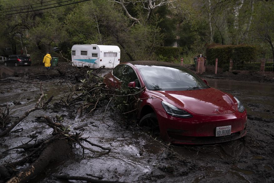 A vehicle is caught up in a mudslide in Silverado Canyon, Calif., Wednesday, March 10, 2021. A Pacific storm brought more much-needed rain and snow to California on Wednesday at the tail-end of a largely dry winter. Winter storm warnings were in effect in the southern Cascades, down the length of the Sierra Nevada and the mountains of Southern California, the National Weather Service said. (AP Photo/Jae C. Hong)